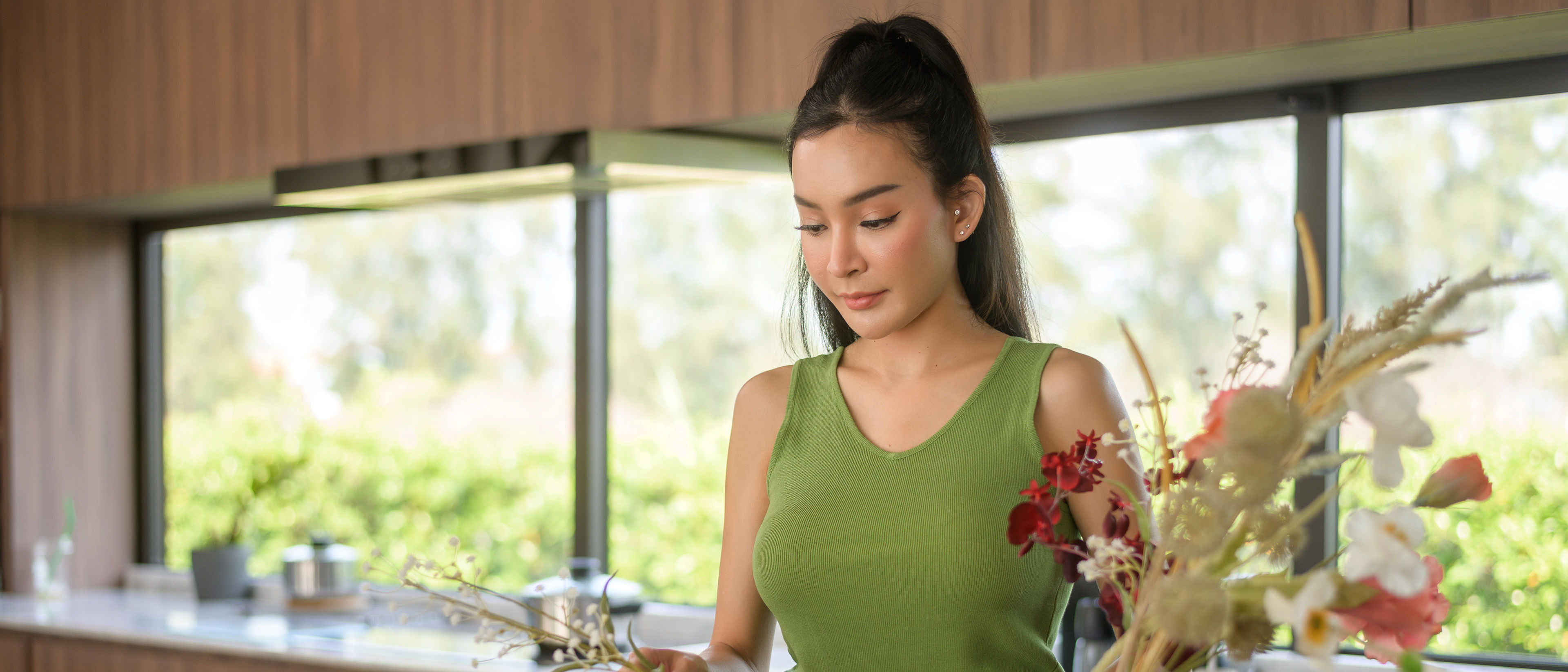 woman putting beautiful flowers on jar